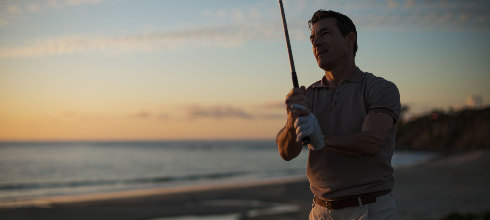 A Person Holding A Fishing Pole On A Beach
